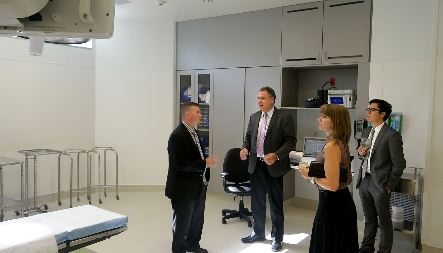 Eric Kuehmeier, center, Crystal McMahon and Ricardo Munoz, right, talk with a tour guide during the grand opening of the Fort Worth Baylor Surgical Hospital. - Page