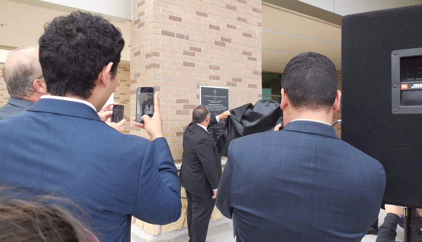 Officials unveil a dedication plaque outside the El Paso Neighborhood Healthcare Center East Clinic. - Page